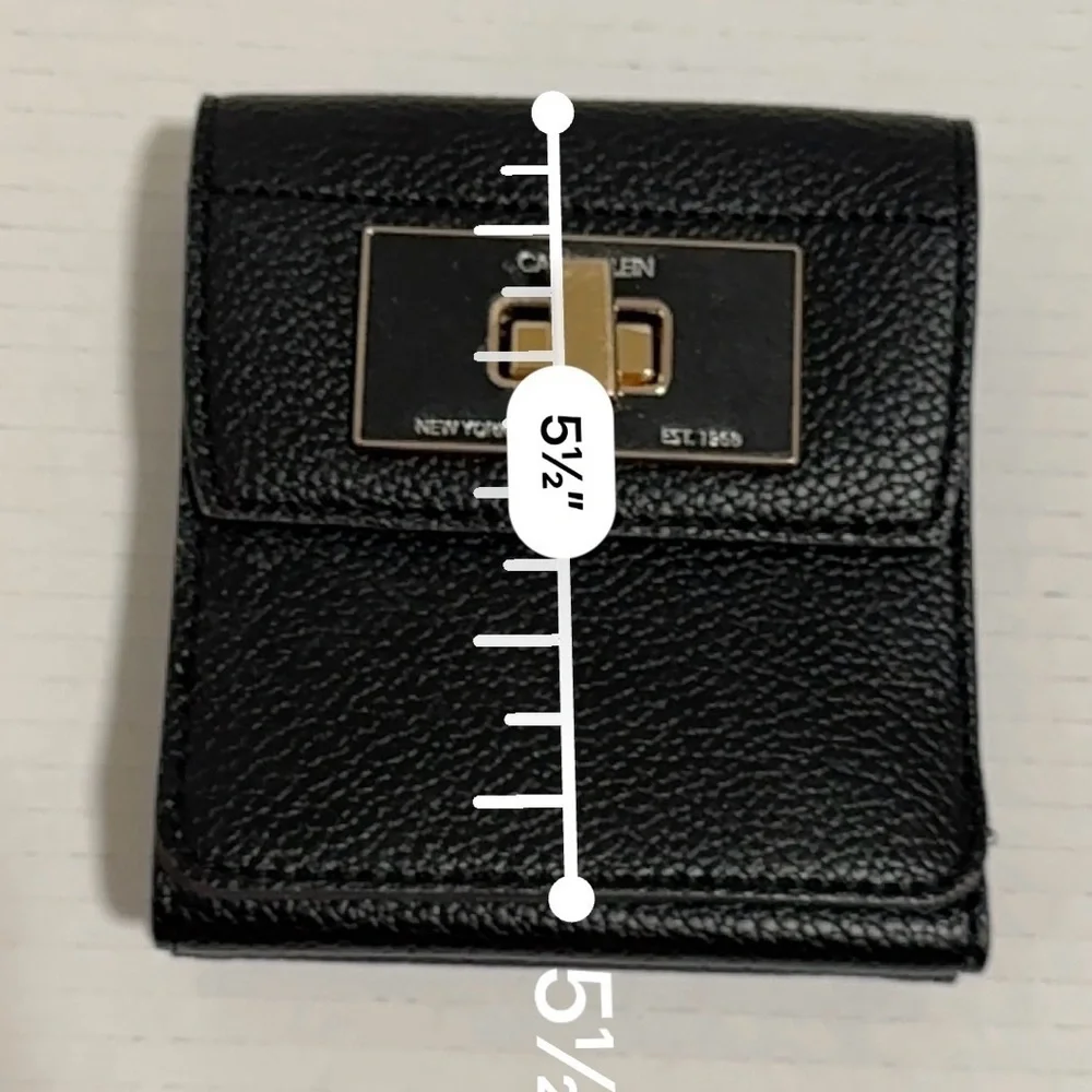 Calvin Klein black trifold wallet with a gold-tone metal closure